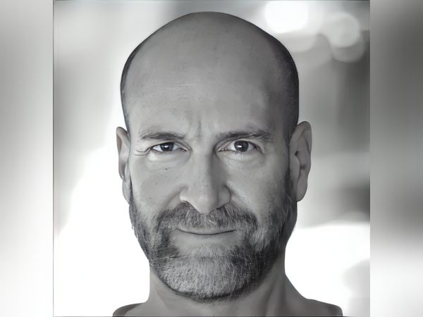Portrait of a bald man with a beard and a calm expression.