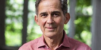 Smiling middle-aged man in a casual shirt outdoors.