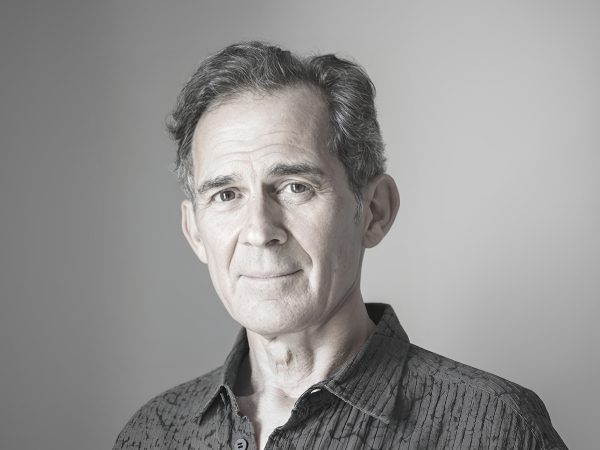 Portrait of a middle-aged man with a neutral expression against a plain background.