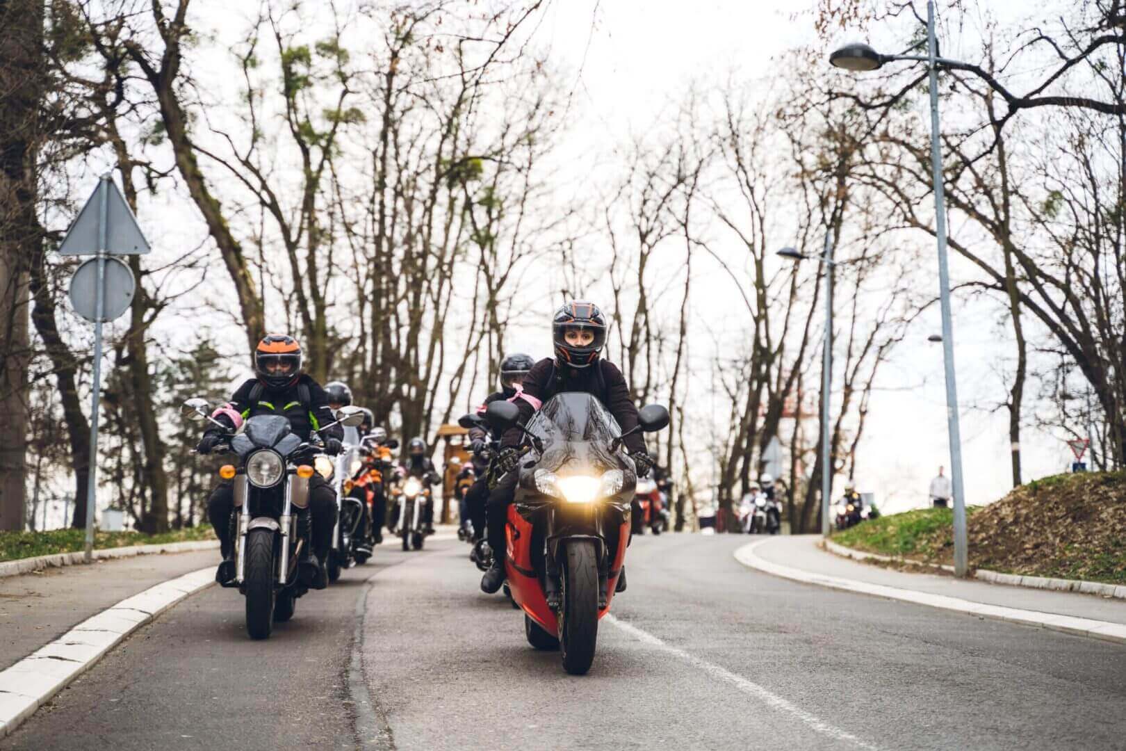 Group of motorcyclists riding on road.