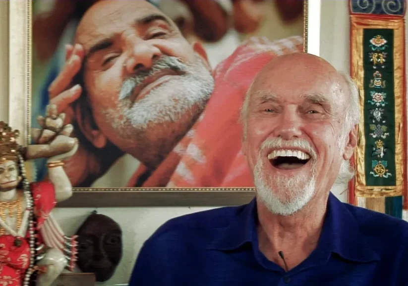 Smiling man with spiritual decor and portrait.